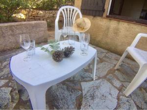 - une table blanche avec des verres à vin et des cônes de pin dans l'établissement Maison Porto-Vecchio, 3 pièces, 6 personnes - FR-1-62-152, à Porto-Vecchio