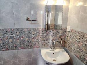 a bathroom with a sink and a mirror at Cosy Quiet Little Apartment In Kathmandu in Bungmati +1 photo