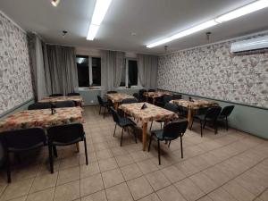 um restaurante com mesas e cadeiras num quarto em Kalamaja Hostel em Kuressaare