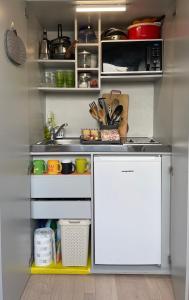 a kitchen with a sink and a white refrigerator at Delizioso attico privato, comfort, cool. in Milan