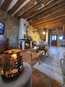 a living room with a fireplace and a stone wall at La Ultima Casa Masboquera in Mas Boquera