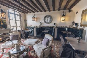 a restaurant with chairs and tables and a clock on the wall at Le Patio & Spa in Saumur