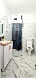 a white bathroom with a toilet and a shower at Apartament momA Oradea in Oradea