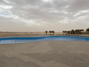 a swimming pool in the middle of the desert at Sidra Resort in Buqayq