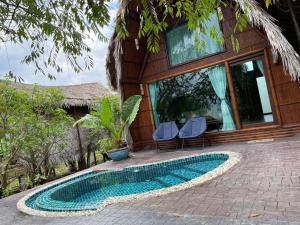 a house with a swimming pool in front of a house at Villa Baan Pak Pra in Ban Pak Pra (1)