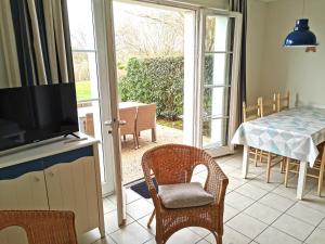 een woonkamer met een televisie en een tafel en stoelen bij Residence Le Bocage - Piscine chauffee in Talmont
