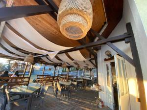 a restaurant with tables and chairs and a ceiling at Pensiunea Ioana in Rugineşti