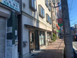 uma rua com um edifício e um poste num passeio em Lodging Tokyo Uguisudani em Tóquio