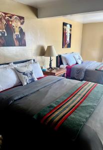 a bedroom with two beds and a table with a lamp at Lodge at Poncha Springs in Salida