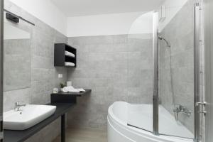 a bathroom with a tub and a sink and a shower at Parizs Garden Apartments in Debrecen +48 photos