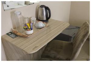 una mesa de madera con una cafetera. en Haithoms B&B Tlokweng-Gaborone, en Tlokweng