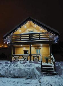 a house with lights on top of it in the snow at Domki u Basi in Kluszkowce