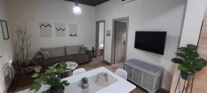 ein Wohnzimmer mit einem Sofa und einem Tisch in der Unterkunft Seaside house for 8 close to Olympia & the beach in Levendokhórion