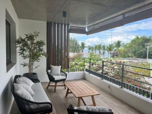 sala de estar con balcón con vistas al océano en Résidence UltraMarine, en Boucan Canot