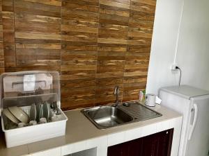 uma cozinha com um lavatório e uma parede de madeira em Pakdee House em Udon Thani
