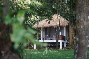Villa Allure Koh Mak في كو ماك: كوخ صغير بسقف من القش ومرجيح