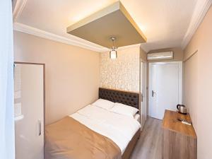 ein kleines Schlafzimmer mit einem Bett mit weißen Laken in der Unterkunft Helen Inn in Izmir + 10 Fotos