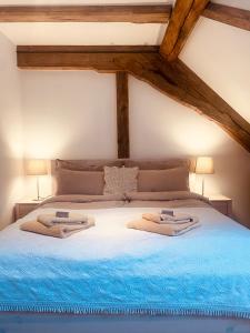 a bedroom with a bed with two towels on it at Benefizium Denklingen - Anno 1713 in Denklingen