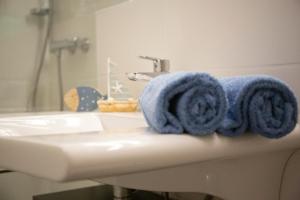 Baño con toallas azules en un lavabo en Ferienwohnung mitten in Saarburg en Saarburg