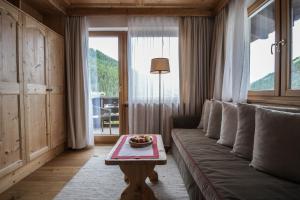 a living room with a couch and a table at Hotel Tyrol in Selva di Val Gardena