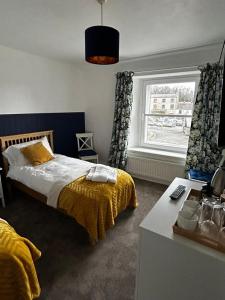 een slaapkamer met een bed en een raam bij Haven House in Leyburn