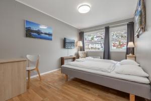 a bedroom with a bed and a desk and a window at Gaupnetunet Hotell og Hytter in Gaupne +21 photos
