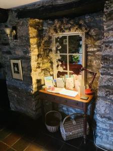 a desk with a window in a stone wall at Ty Mawr Country Hotel in Carmarthen