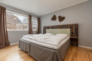 ein großes Bett in einem Zimmer mit einem großen Fenster in der Unterkunft Gaupnetunet Hotell og Hytter in Gaupne