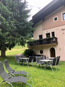 a group of chairs and tables in the grass in front of a building at Appartements Kröll in Saalbach-Hinterglemm