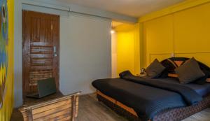 a bedroom with a bed and a laptop on a table at Whoopers Hostel Tosh in Tosh