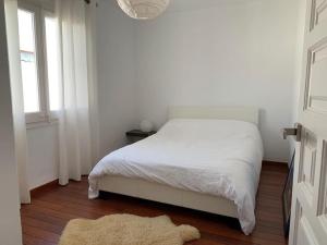 1 dormitorio con cama blanca y ventana en Maison 3 chambres proche plage amarre 7 m, en Empuriabrava