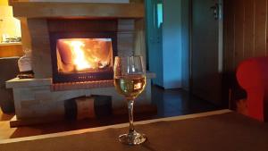 a glass of wine sitting on a table in front of a fireplace at Czernyszówka in Bystre