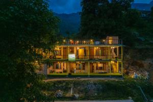 a large house with lights on it at night at Whoopers Hostel Tosh in Tosh
