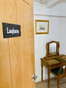 une porte en bois avec une pancarte à côté d'une table dans l'établissement Ty Mawr Country Hotel, à Carmarthen