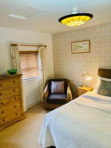 a bedroom with a bed and a chair and a window at Ty Mawr Country Hotel in Carmarthen
