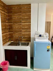 a small kitchen with a sink and a refrigerator at Pakdee House in Udon Thani