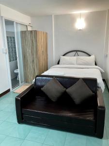 a bedroom with a bed with a bench in it at Pakdee House in Udon Thani