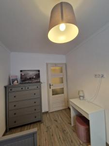 Pokój z komodą, lampką i biurkiem w obiekcie Apartament Górska Panorama w Szklarskiej Porębie
