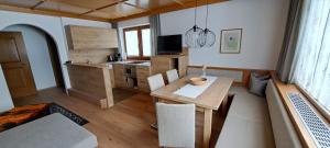 a living room with a table and a kitchen at Apartment Martina in Ramsau im Zillertal