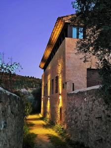 an old stone building with a wall next to a road at Casas Rurales El Parador in Letur