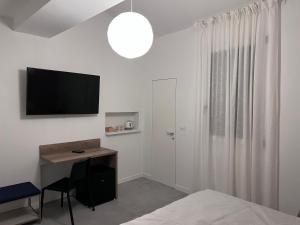 una camera da letto con una scrivania e una televisione a parete di Quiet Room a Bologna