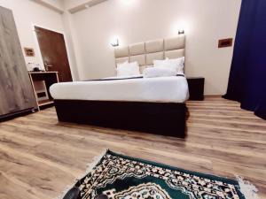 ein Schlafzimmer mit einem großen Bett und einem Teppich in der Unterkunft GULSHAN PALACE in Srinagar