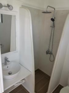 Baño blanco con lavabo y espejo en Villa Rizia en Kolimbia