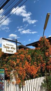ein Schild für ein Top-Stay-Hotel neben einem Zaun in der Unterkunft topp stay hostel in Pai