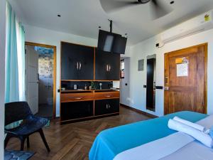 a bedroom with a bed and a chair and a television at Mel Ville in Puducherry