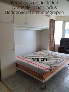 a bed in a room with avertisement for at Le 7ème Ciel Westende in Middelkerke