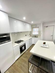 a kitchen with white cabinets and a white counter top at Lotus Stay Manly - Apartment 31E in Sydney