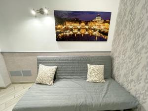 un sofá con dos almohadas sentado bajo una pintura en Eufonia Vatican Days, en Roma