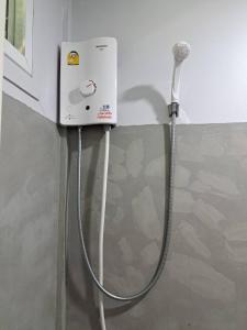 a washing machine with a hose attached to a wall at Hunny Home in Ko Yao Noi