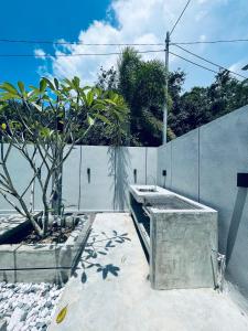un jardín con un fregadero de hormigón y una valla en The Groove House Private Pool & BBQ by Linese Homestay, en Kuah